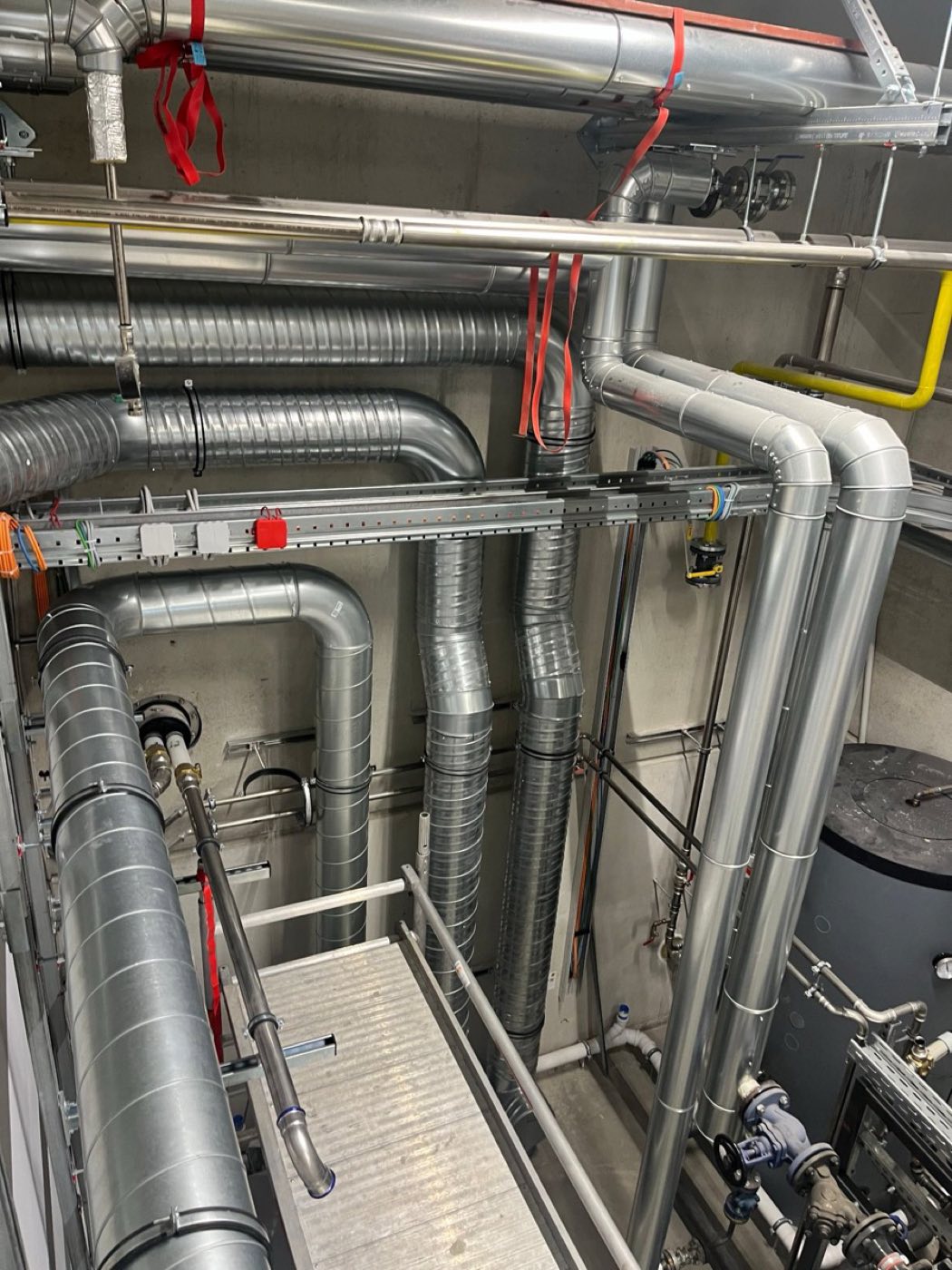 Technikzentrale mit Rohrleitungen, Speicher und Wartungssteg